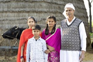 Rural Indian family posing in front of buffalo